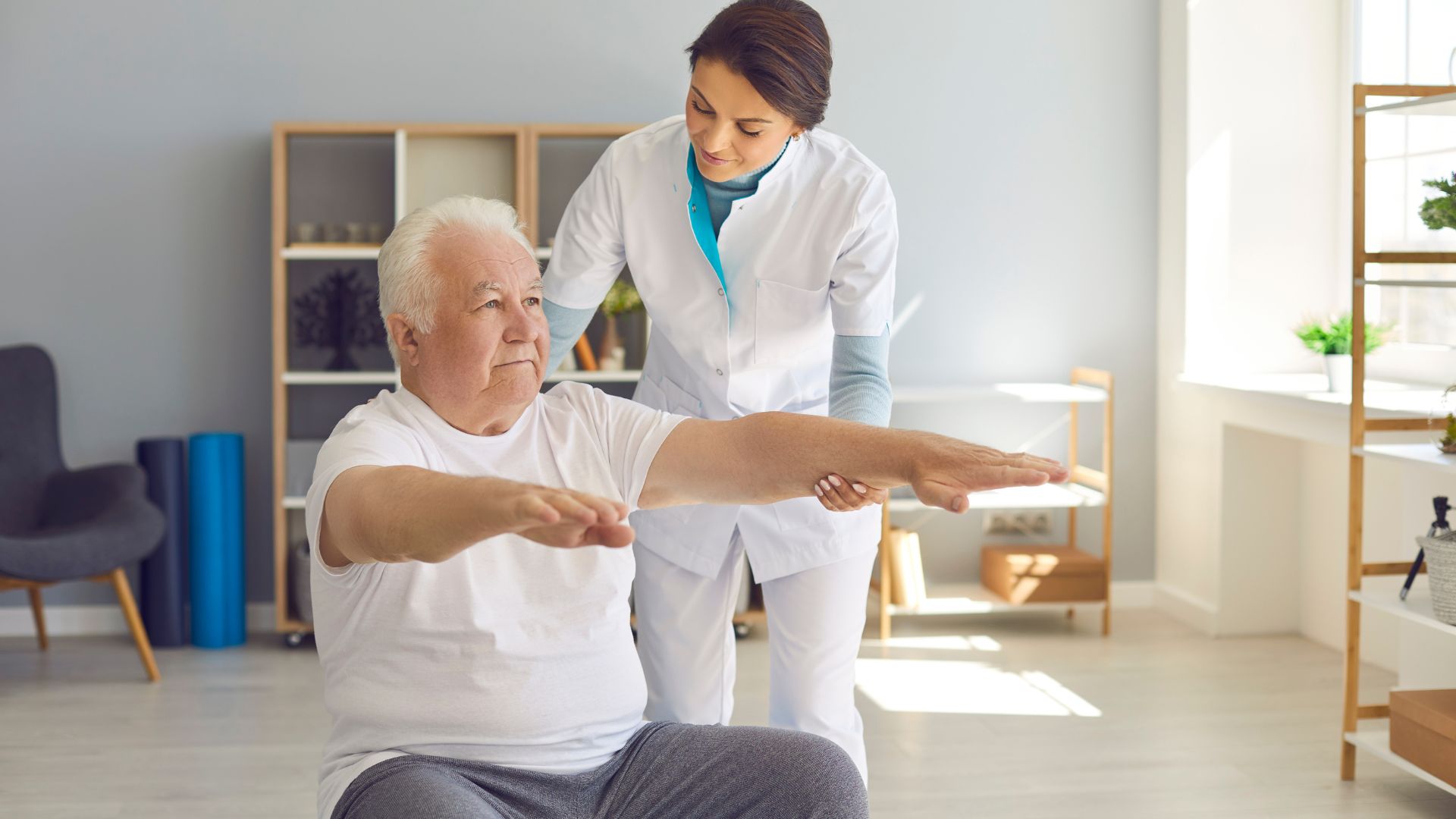 Senior Man in Room Supporting His Outstretched Arms With A Chiropractor